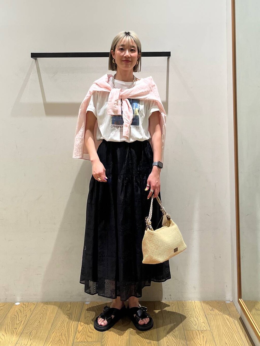 ベージュ系のショルダーバッグ、ブラック系のサンダル、ピンク系のシャツ/ブラウスを着用したレディースの春コーディネートの5枚目の写真