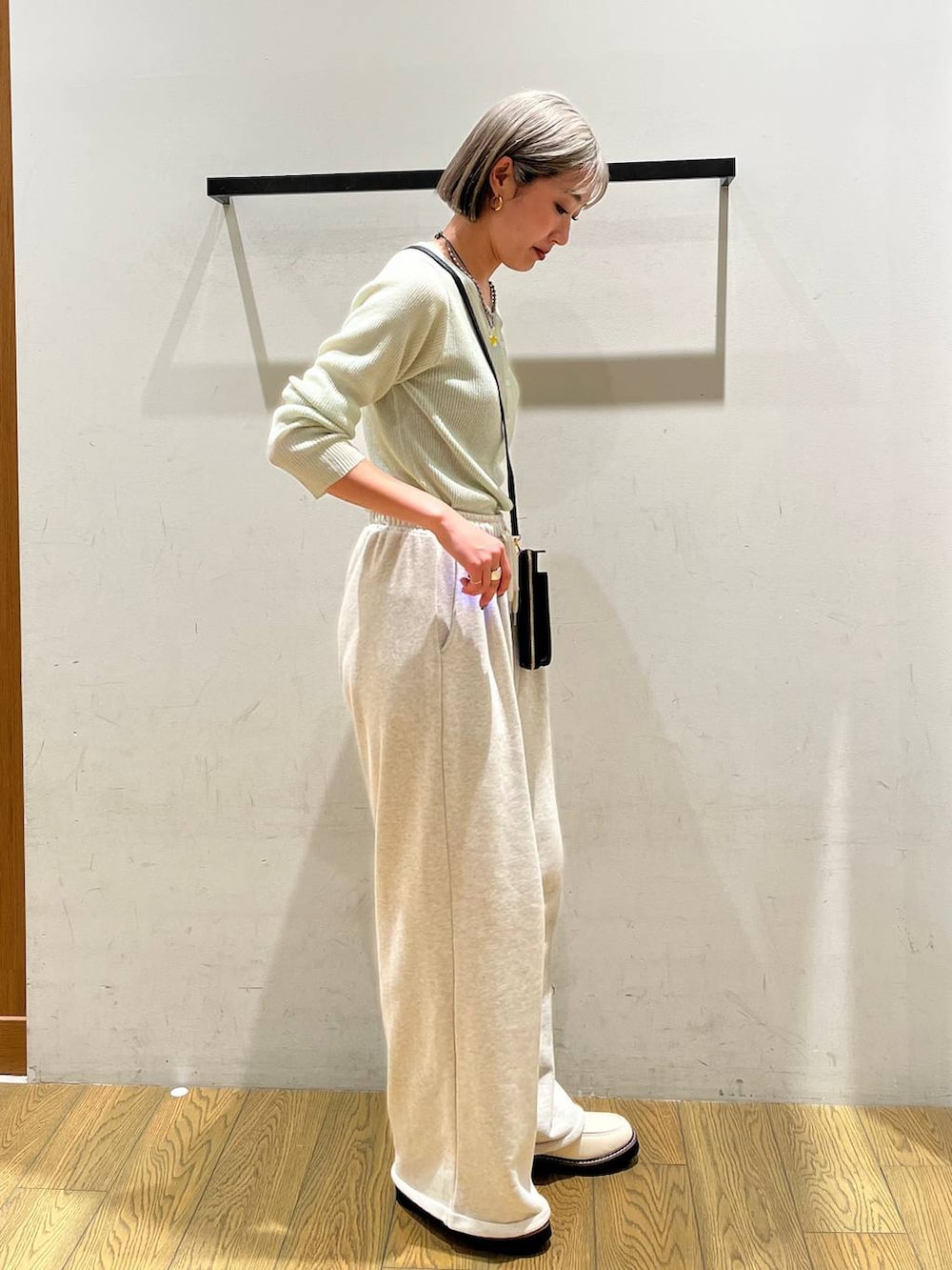 ホワイト系のローファー、グリーン系のカーディガン/ボレロ、ブラック系の財布を着用したレディースの春コーディネートの2枚目の写真