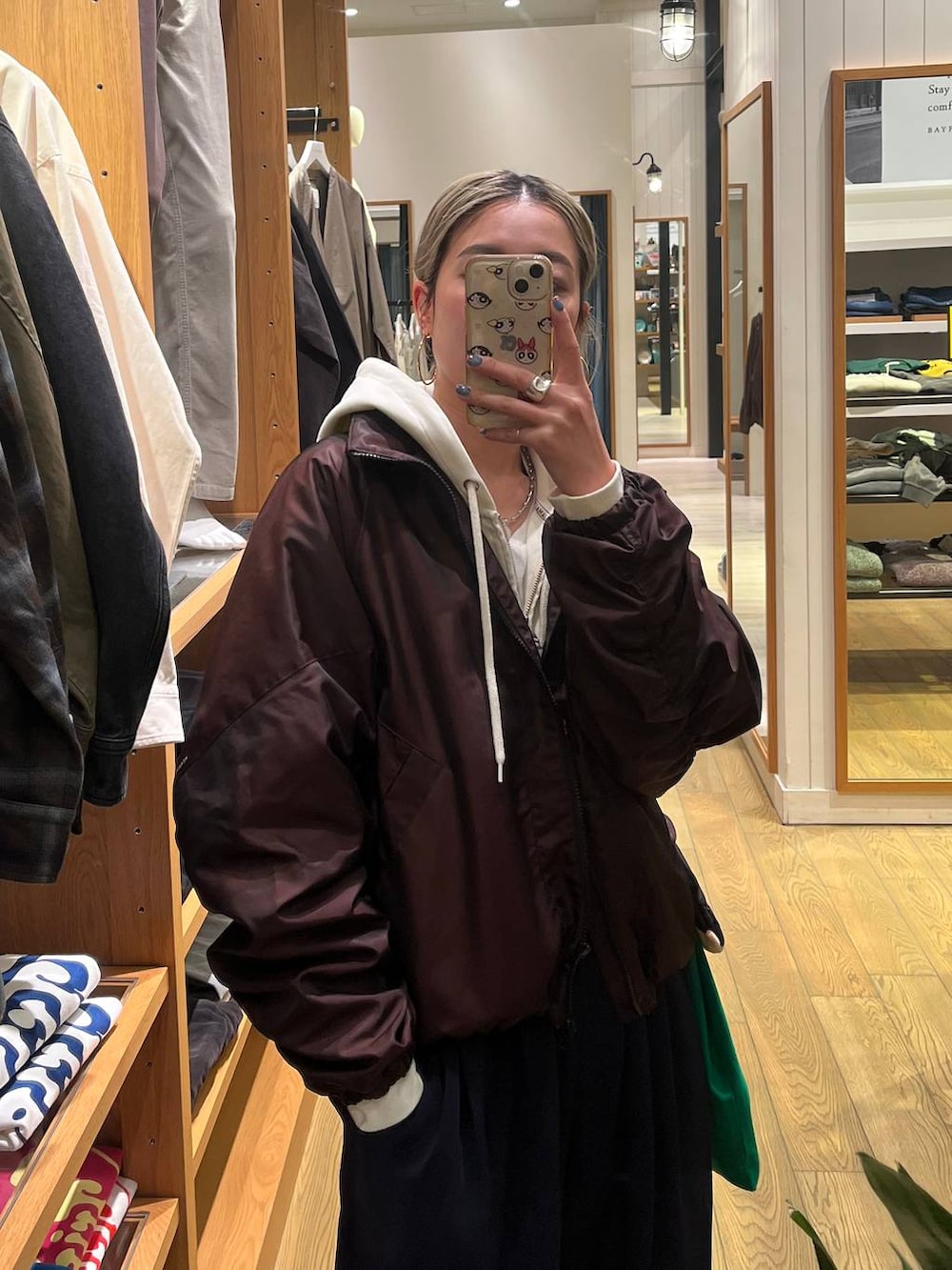 ブラウン系のブルゾン、ブルー系のその他パンツ、ベージュ系のパーカーを着用したレディースの春コーディネートの2枚目の写真