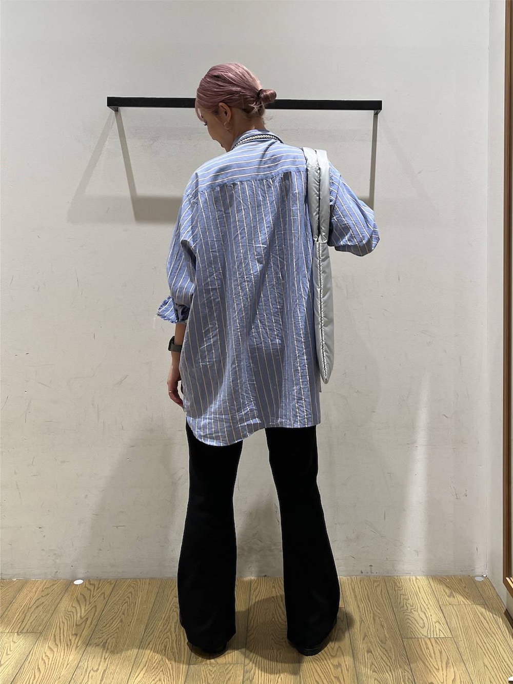 ブルー系のチュニック、シルバー系のトートバッグ、ブラック系のその他パンツを着用したレディースの秋コーディネートの4枚目の写真
