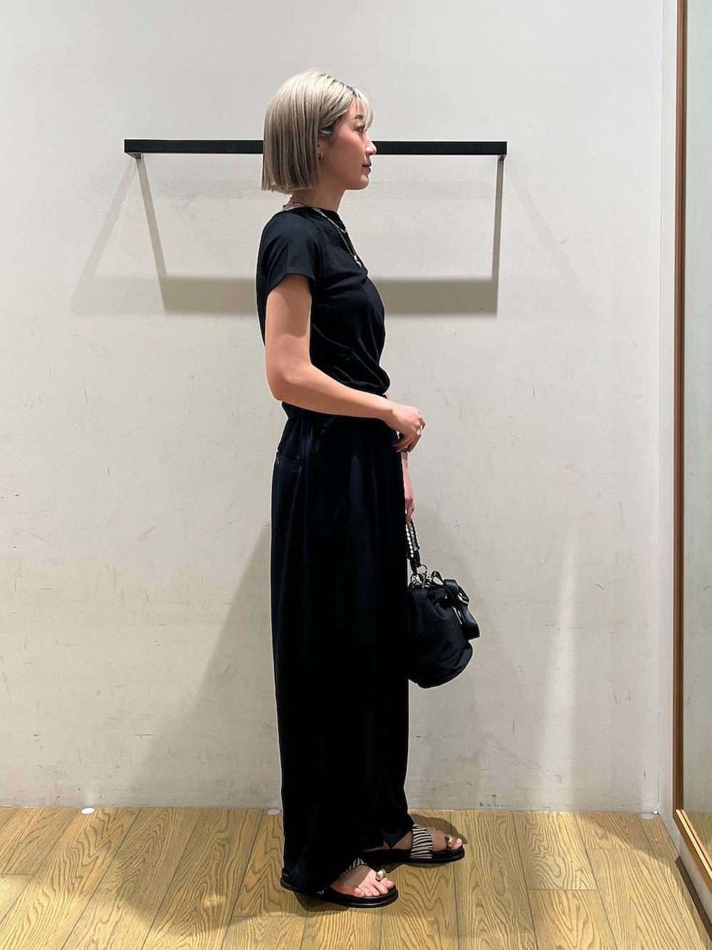ブルー系のその他パンツ、ブラック系のショルダーバッグ、その他のサンダルを着用したレディースの春コーディネートの2枚目の写真