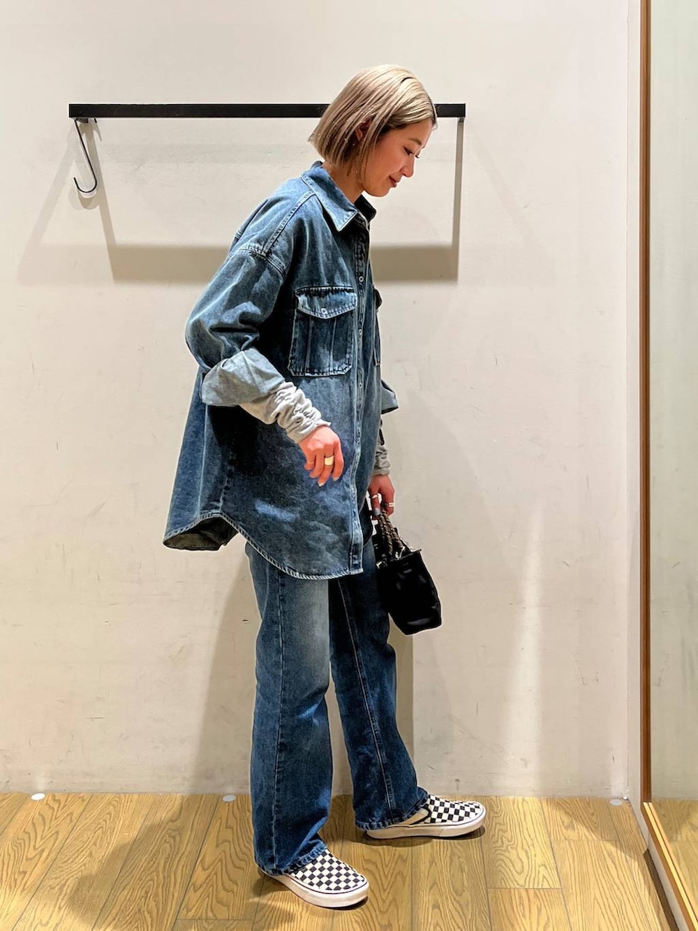 ブルー系のデニムパンツ、ブルー系のシャツ/ブラウス、ブラック系のショルダーバッグを着用したレディースの冬コーディネートの2枚目の写真