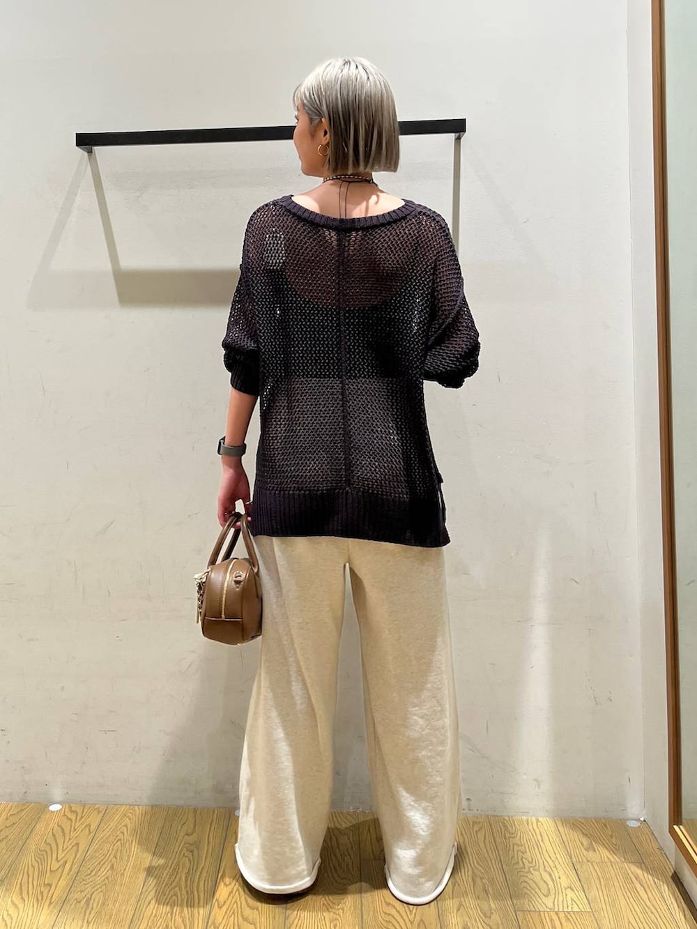 ブラウン系のハンドバッグ、ブラック系のインナーウェア/肌着を着用したレディースの春コーディネートの4枚目の写真