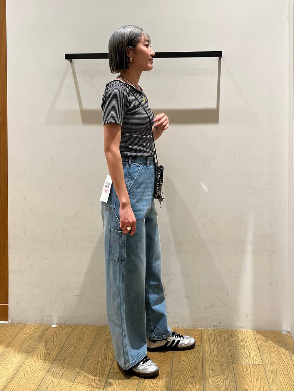 ベージュ系のショルダーバッグ、ブルー系のデニムパンツ、ブラック系のTシャツ/カットソーを着用したレディースの春コーディネートの3枚目の写真