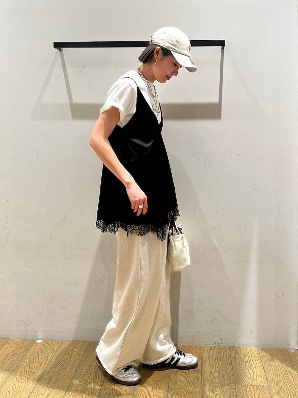 ブラック系のキャミソール、ホワイト系のTシャツ/カットソー、ホワイト系のショルダーバッグを着用したレディースの春コーディネートの2枚目の写真