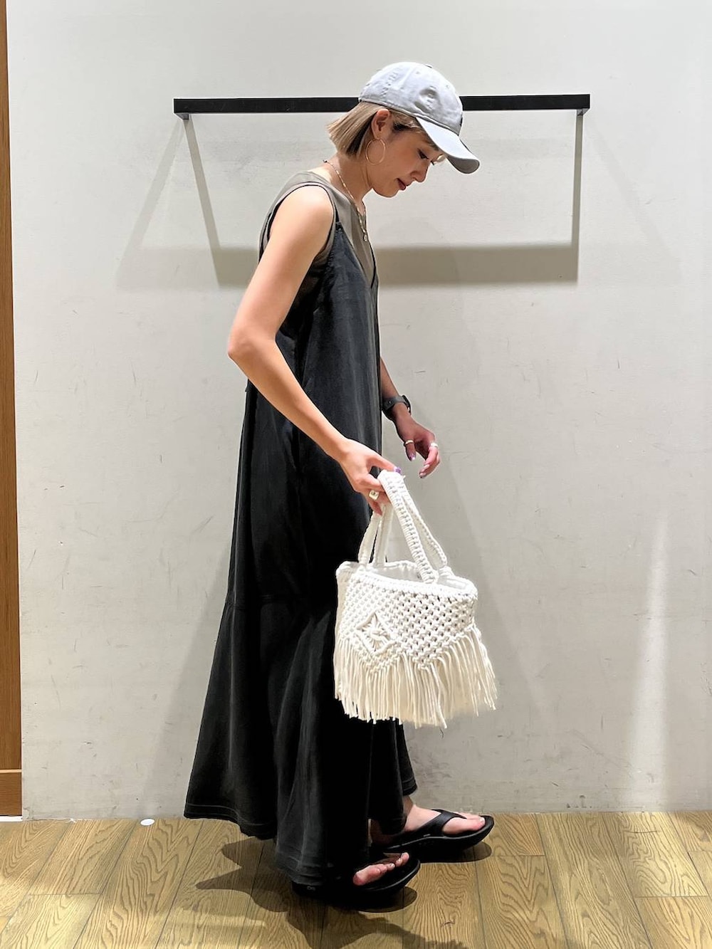 ベージュ系のトートバッグ、ブラウン系のTシャツ/カットソー、ブラック系のサンダルを着用したレディースの夏コーディネートの2枚目の写真