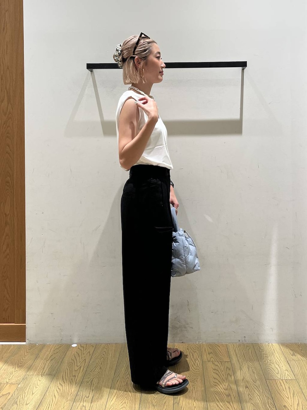 ブルー系のショルダーバッグ、ホワイト系のTシャツ/カットソー、ブラック系のチノパンツを着用したレディースの夏コーディネートの3枚目の写真