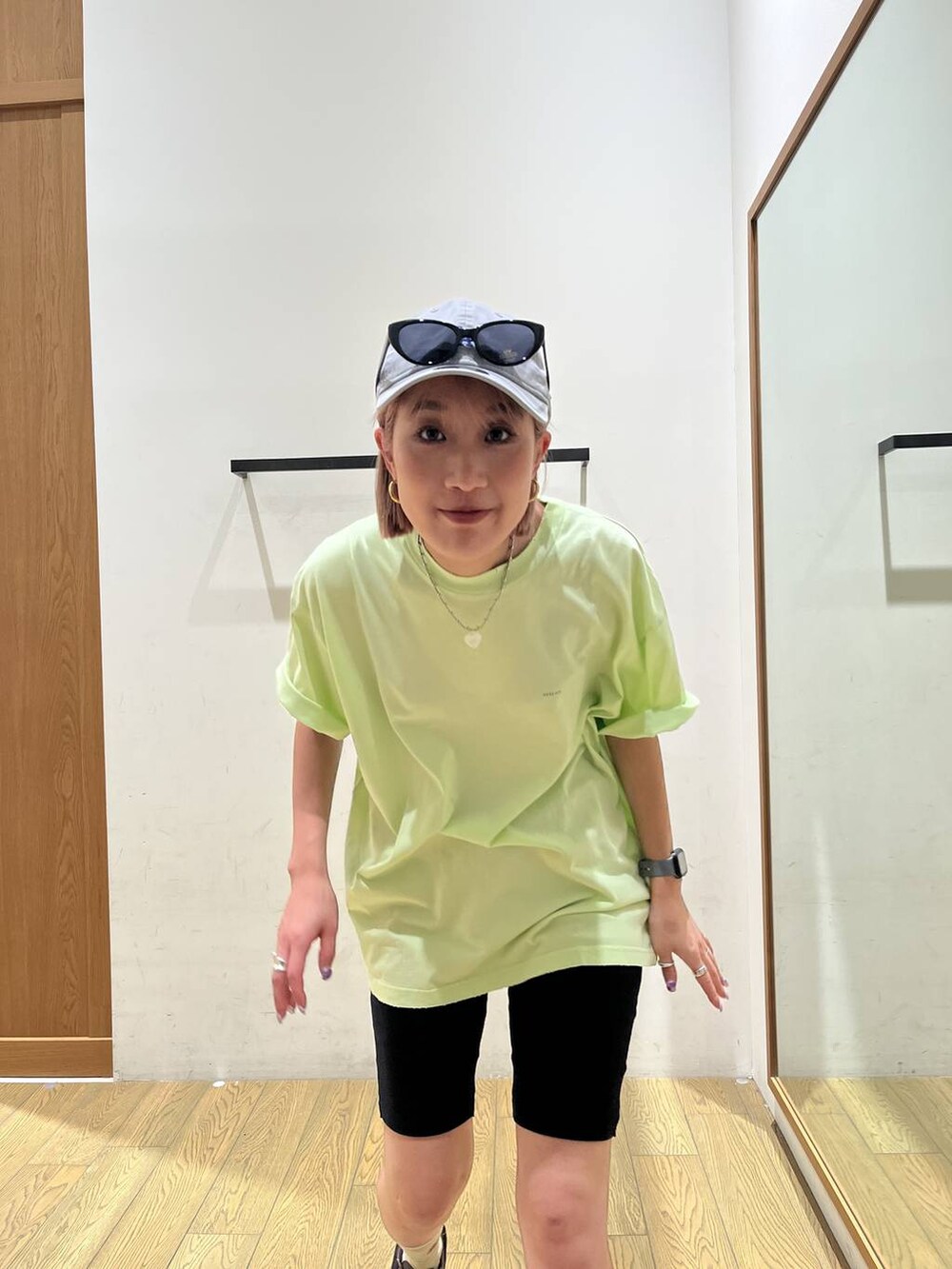 グリーン系のTシャツ/カットソー、グレー系のキャップ、ブラック系のサングラスを着用したレディースの夏コーディネートの5枚目の写真
