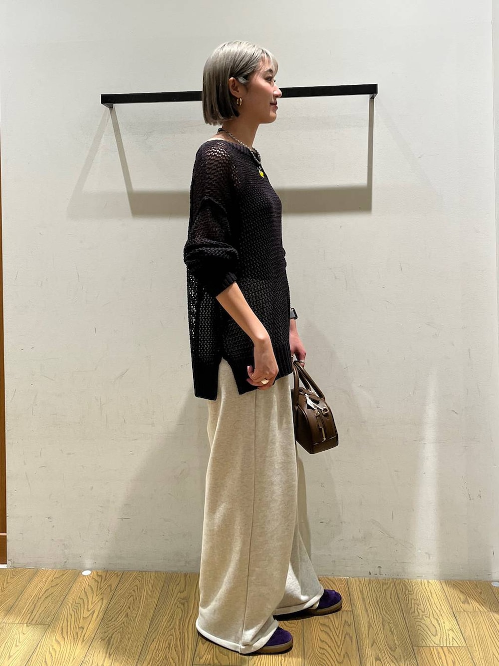 ブラウン系のハンドバッグ、ブラック系のインナーウェア/肌着を着用したレディースの春コーディネートの2枚目の写真