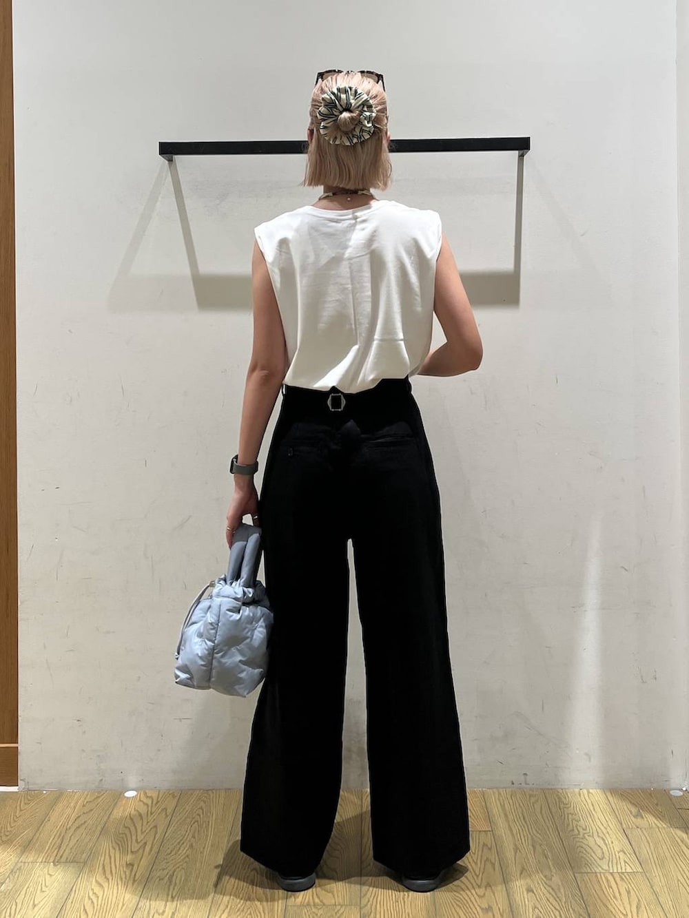 ブルー系のショルダーバッグ、ホワイト系のTシャツ/カットソー、ブラック系のチノパンツを着用したレディースの夏コーディネートの4枚目の写真