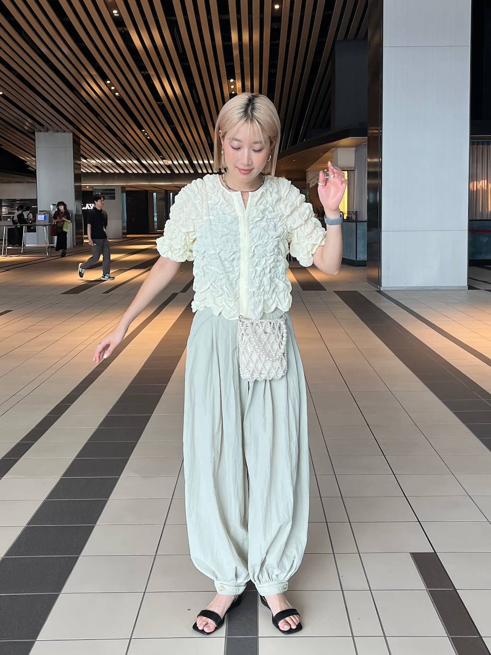 その他のショルダーバッグ、ブラック系のサンダル、グレー系のその他パンツを着用したレディースの夏コーディネートの2枚目の写真