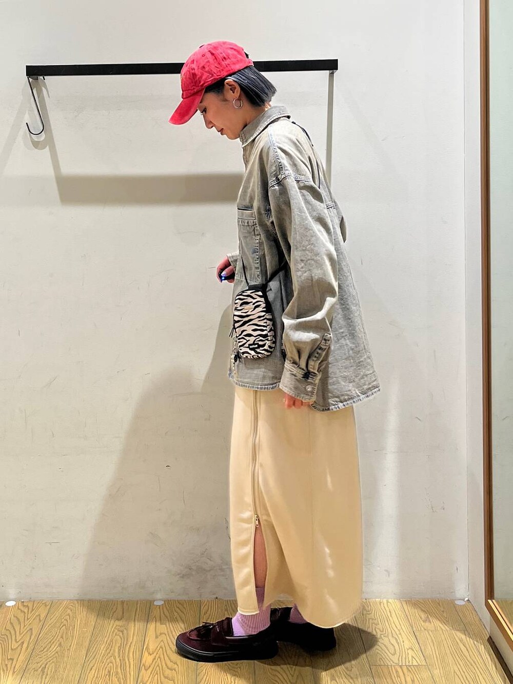 ベージュ系のショルダーバッグ、ベージュ系のスカート、ブルー系のシャツ/ブラウスを着用したレディースの冬コーディネートの2枚目の写真