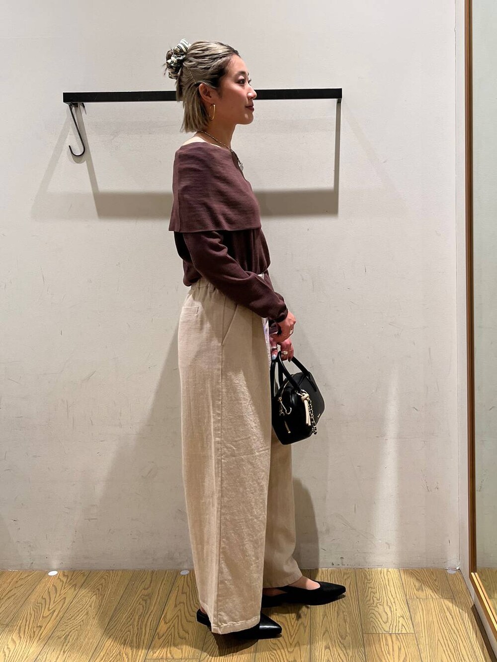 ブラック系のハンドバッグ、ベージュ系のその他パンツを着用したレディースの春コーディネートの2枚目の写真