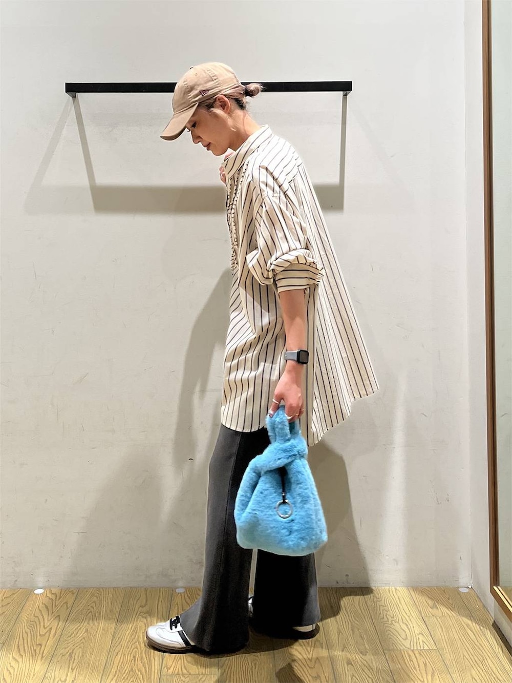 ベージュ系のチュニック、グレー系のその他パンツ、ブルー系のハンドバッグを着用したレディースの秋コーディネートの3枚目の写真