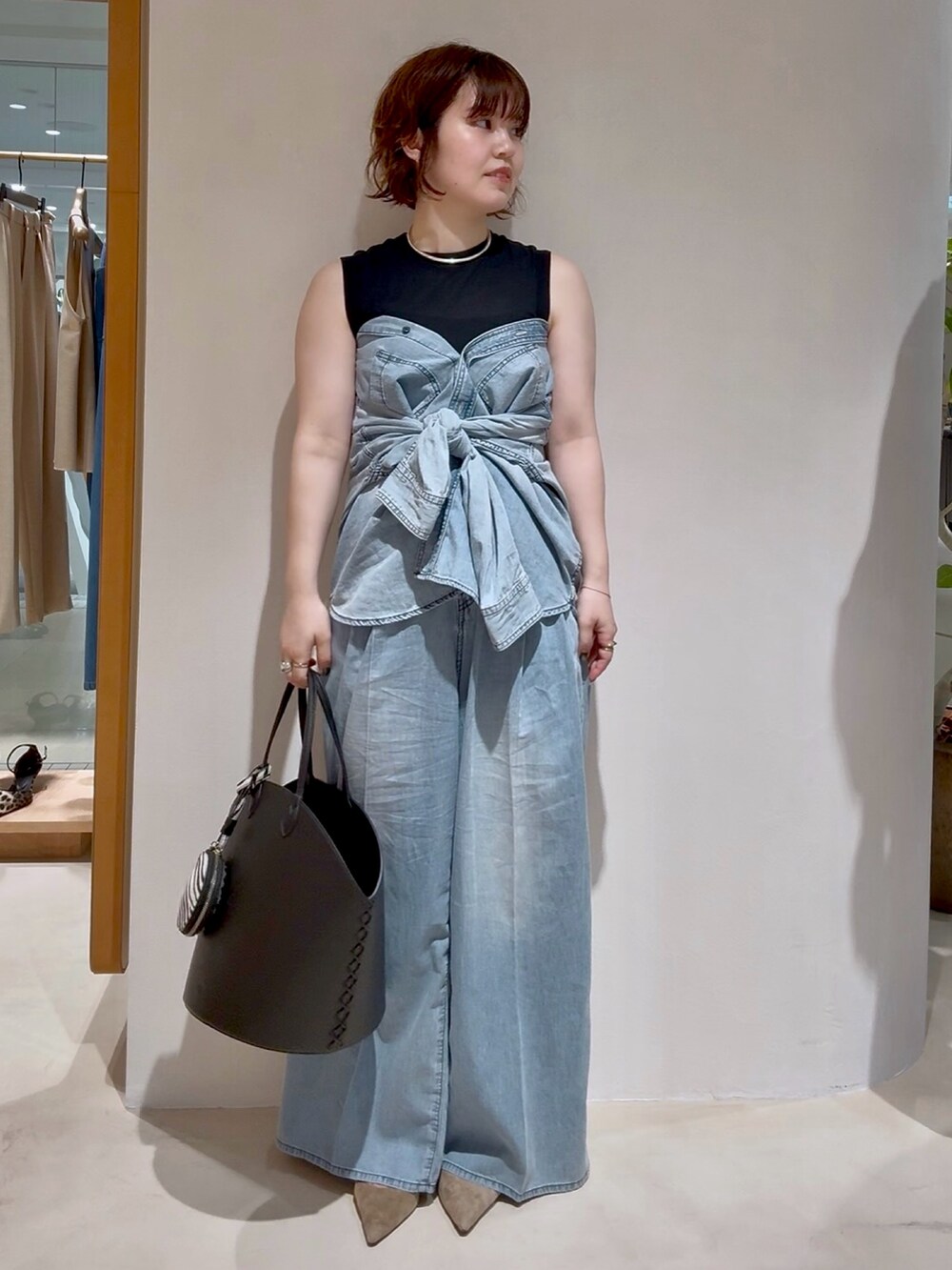 ブルー系のシャツ/ブラウス、ブルー系のデニムパンツ、グレー系のパンプスを着用したレディースの夏コーディネートの4枚目の写真