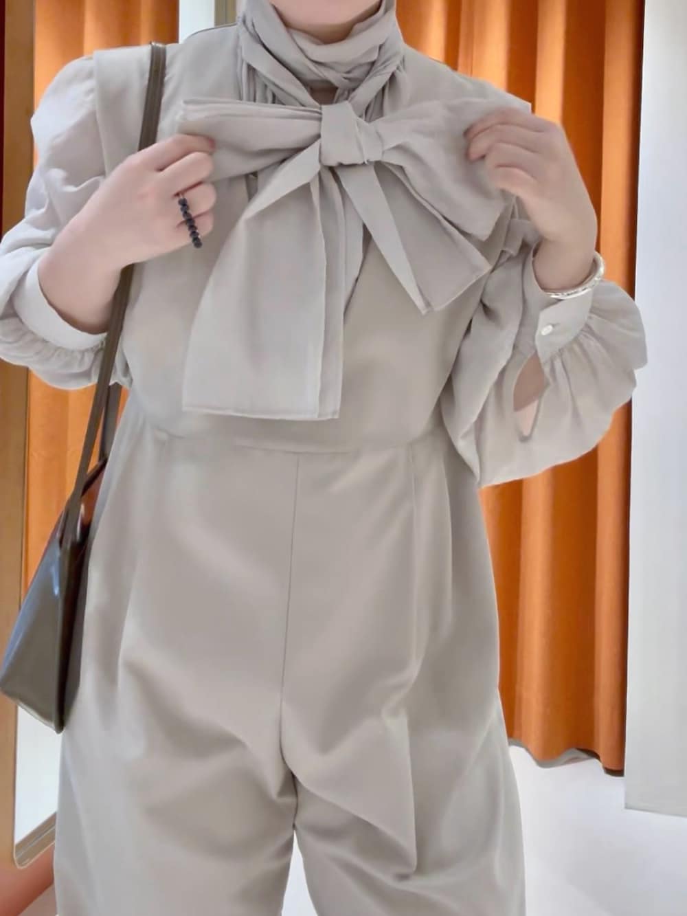 ベージュ系のシャツ/ブラウス、ベージュ系のつなぎ/オールインワン、ブラウン系のショルダーバッグを着用したレディースの春コーディネートの4枚目の写真