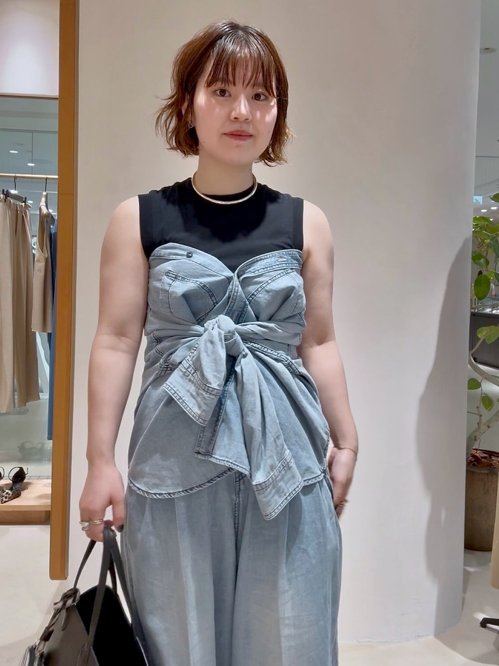 ブルー系のシャツ/ブラウス、ブルー系のデニムパンツ、グレー系のパンプスを着用したレディースの夏コーディネートの3枚目の写真