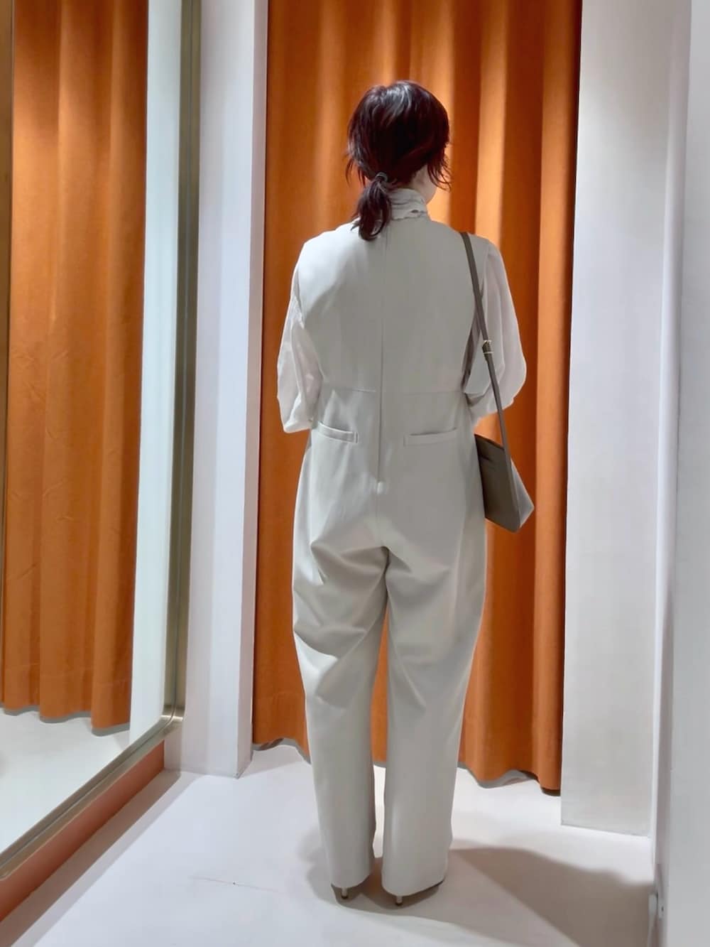 ベージュ系のシャツ/ブラウス、ベージュ系のつなぎ/オールインワン、ブラウン系のショルダーバッグを着用したレディースの春コーディネートの3枚目の写真