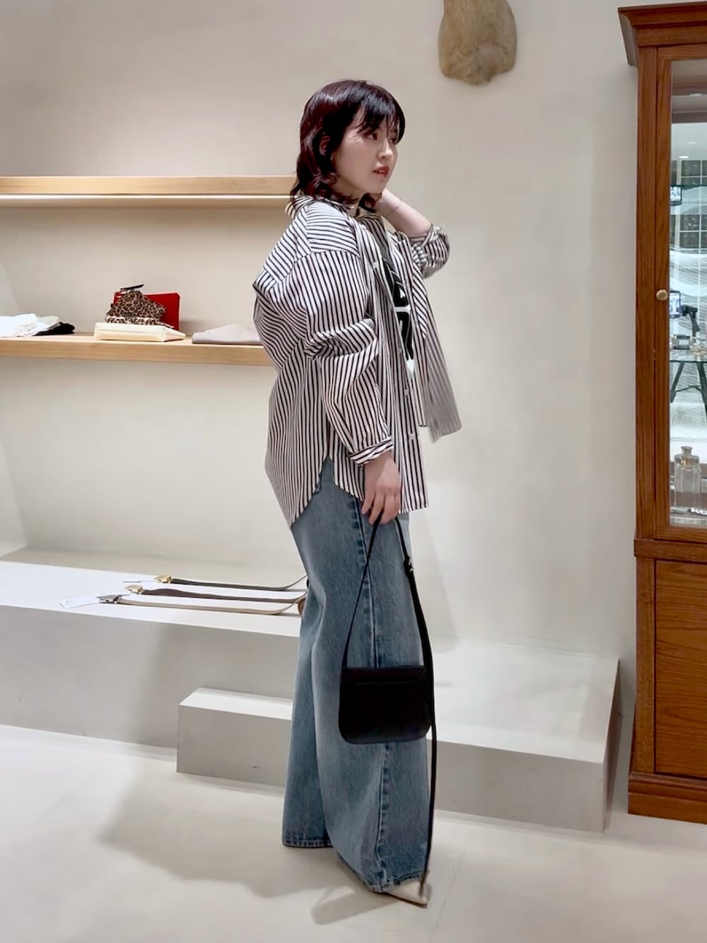 ブルー系のデニムパンツ、ホワイト系のTシャツ/カットソー、ブラウン系のシャツ/ブラウスを着用したレディースの春コーディネートの5枚目の写真