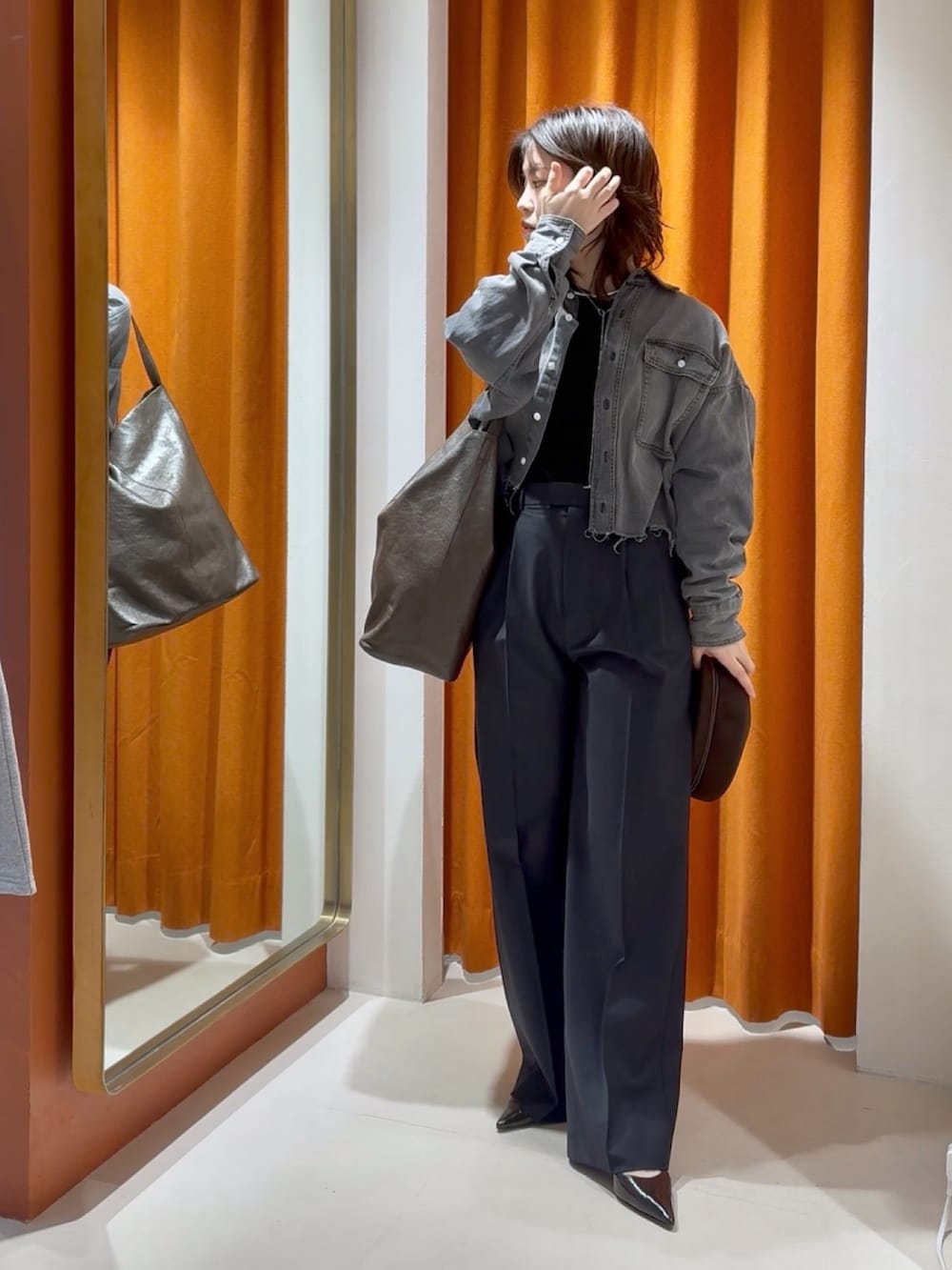 グレー系のシャツ/ブラウス、ブラック系のTシャツ/カットソー、ブラウン系のショルダーバッグを着用したレディースの冬コーディネートの4枚目の写真