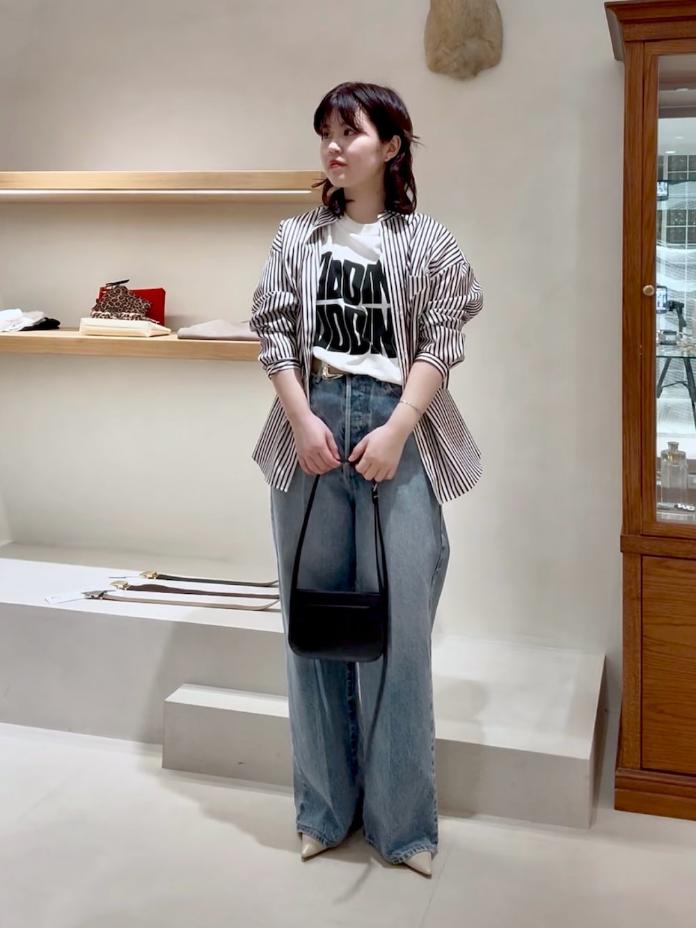 ブルー系のデニムパンツ、ホワイト系のTシャツ/カットソー、ブラウン系のシャツ/ブラウスを着用したレディースの春コーディネートの4枚目の写真