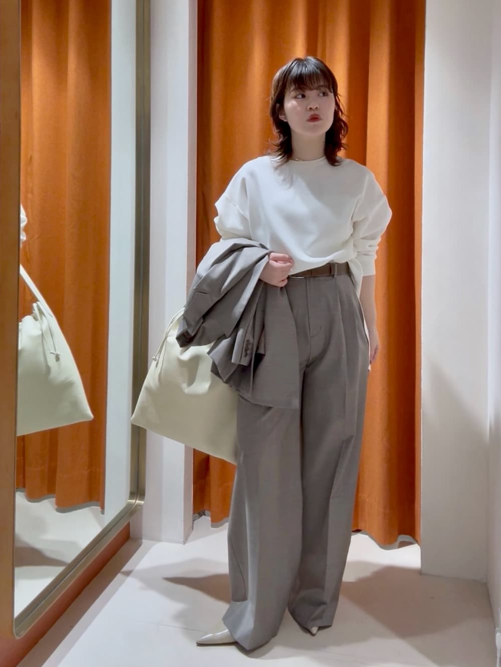 ホワイト系のシャツ/ブラウス、ブラウン系のスラックス、ホワイト系のショルダーバッグを着用したレディースの春コーディネートの4枚目の写真