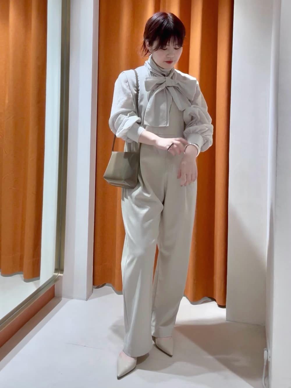 ベージュ系のシャツ/ブラウス、ベージュ系のつなぎ/オールインワン、ブラウン系のショルダーバッグを着用したレディースの春コーディネートの2枚目の写真