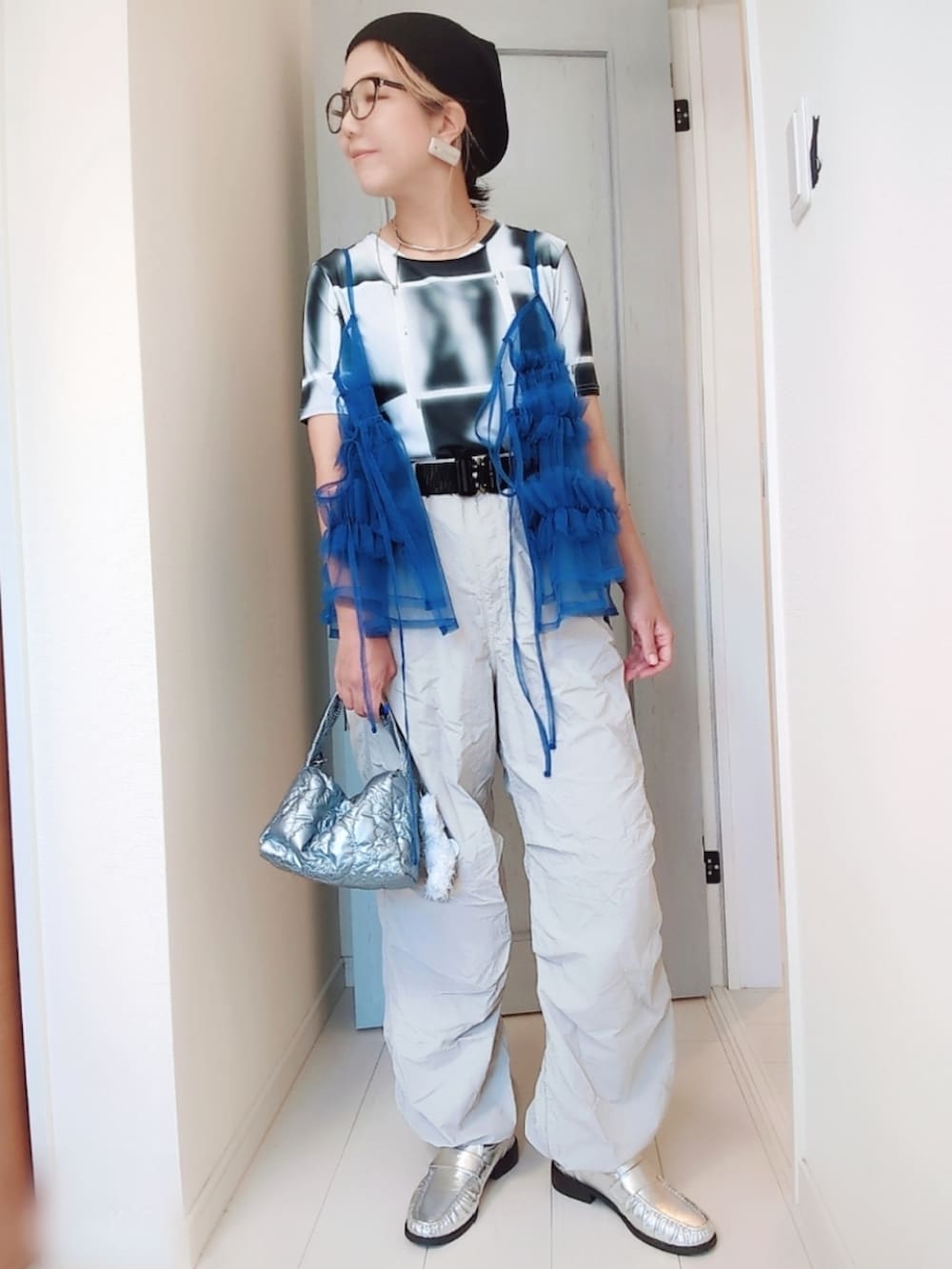 ブラック系のTシャツ/カットソー、ブルー系のキャミソール、グレー系のパンツを着用したレディースの秋コーディネートの2枚目の写真