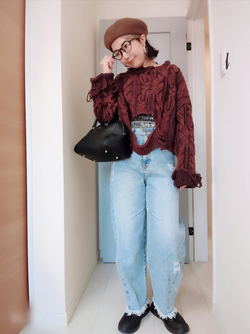 ブラウン系のニット/セーター、シルバー系のチューブトップ、ブルー系のデニムパンツを着用したレディースの冬コーディネートの2枚目の写真