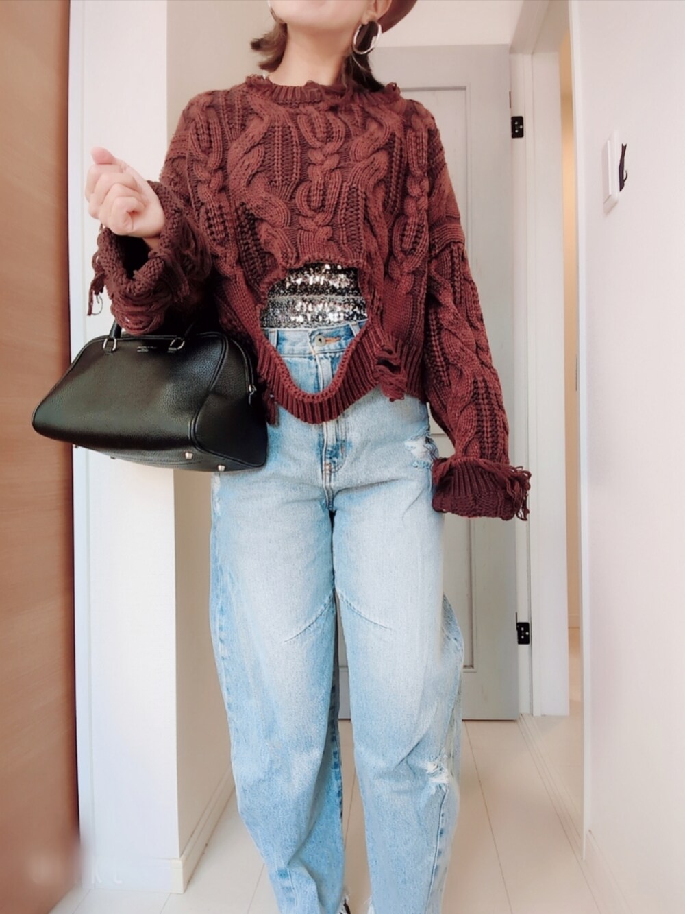 ブラウン系のニット/セーター、シルバー系のチューブトップ、ブルー系のデニムパンツを着用したレディースの冬コーディネートの3枚目の写真