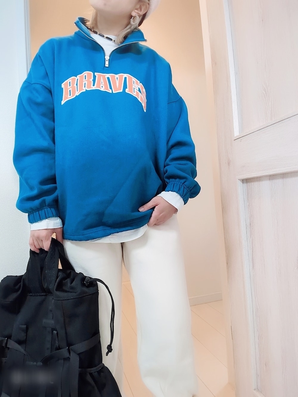 ブルー系のスウェット、ベージュ系のスウェットパンツ、ホワイト系のスニーカーを着用したレディースの春コーディネートの3枚目の写真