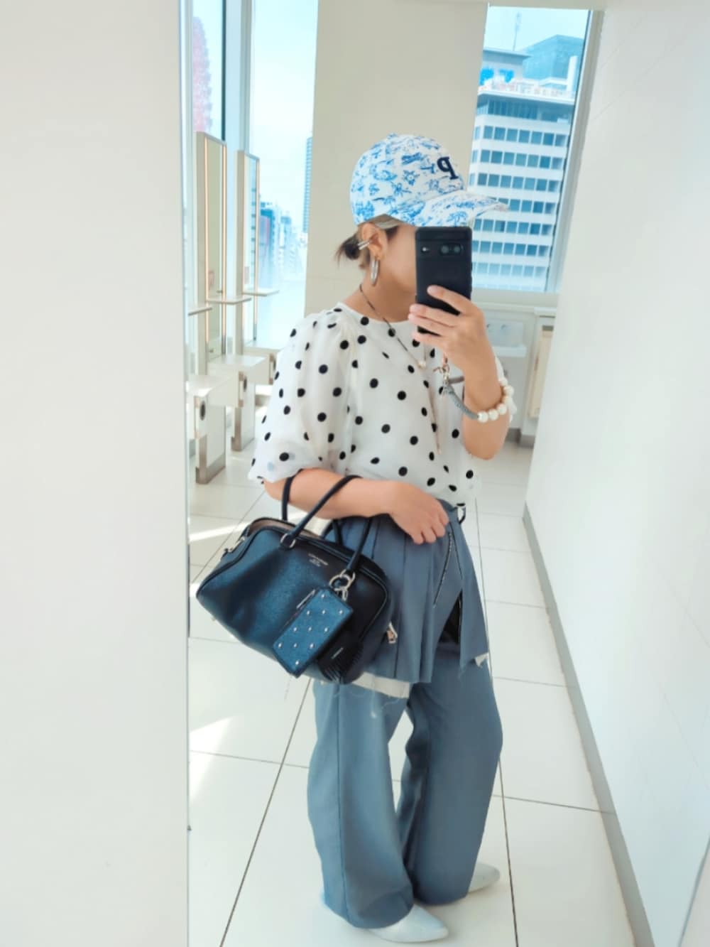 ホワイト系のシャツ/ブラウス、グレー系のスラックス、ホワイト系のスニーカーを着用したレディースの秋コーディネートの2枚目の写真