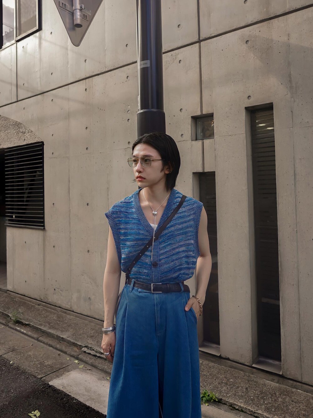 ブルー系のデニムパンツ、ブラック系のブーツ、ブルー系のベストを着用したメンズの夏コーディネートの4枚目の写真