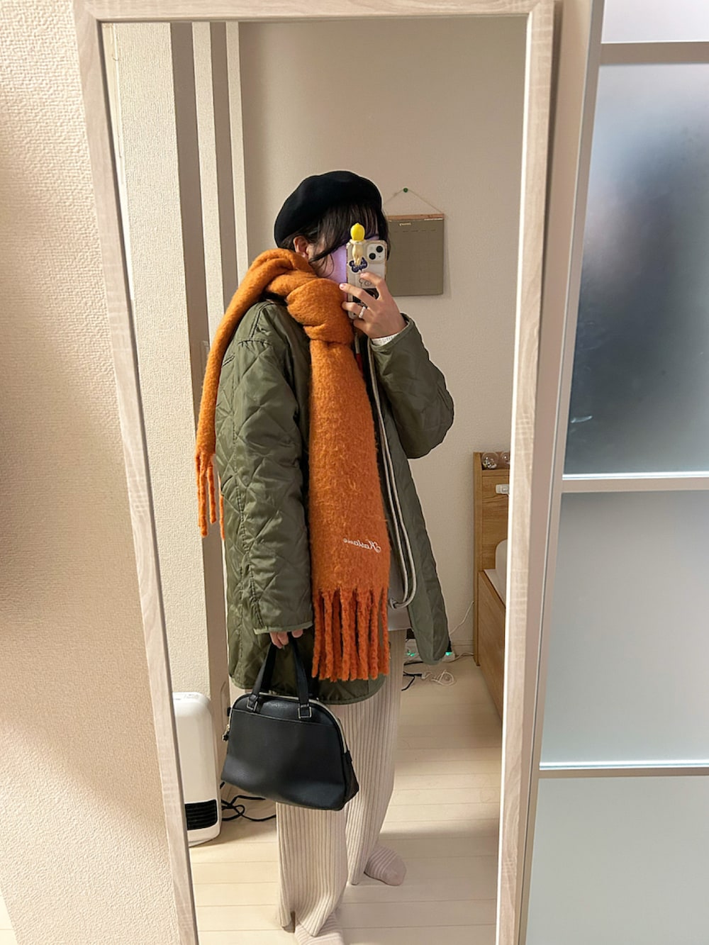 ブラック系のニット/セーター、ホワイト系のシャツ/ブラウス、ベージュ系のその他パンツを着用したレディースの冬コーディネートの2枚目の写真