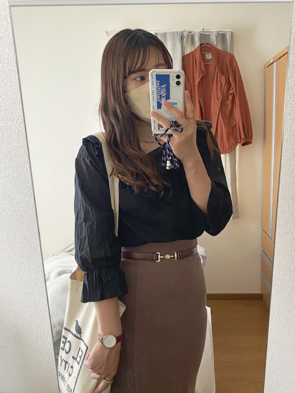 ブラック系のシャツ/ブラウス、ブラウン系のスカート、ブラック系のブーツを着用したレディースの春コーディネートの2枚目の写真