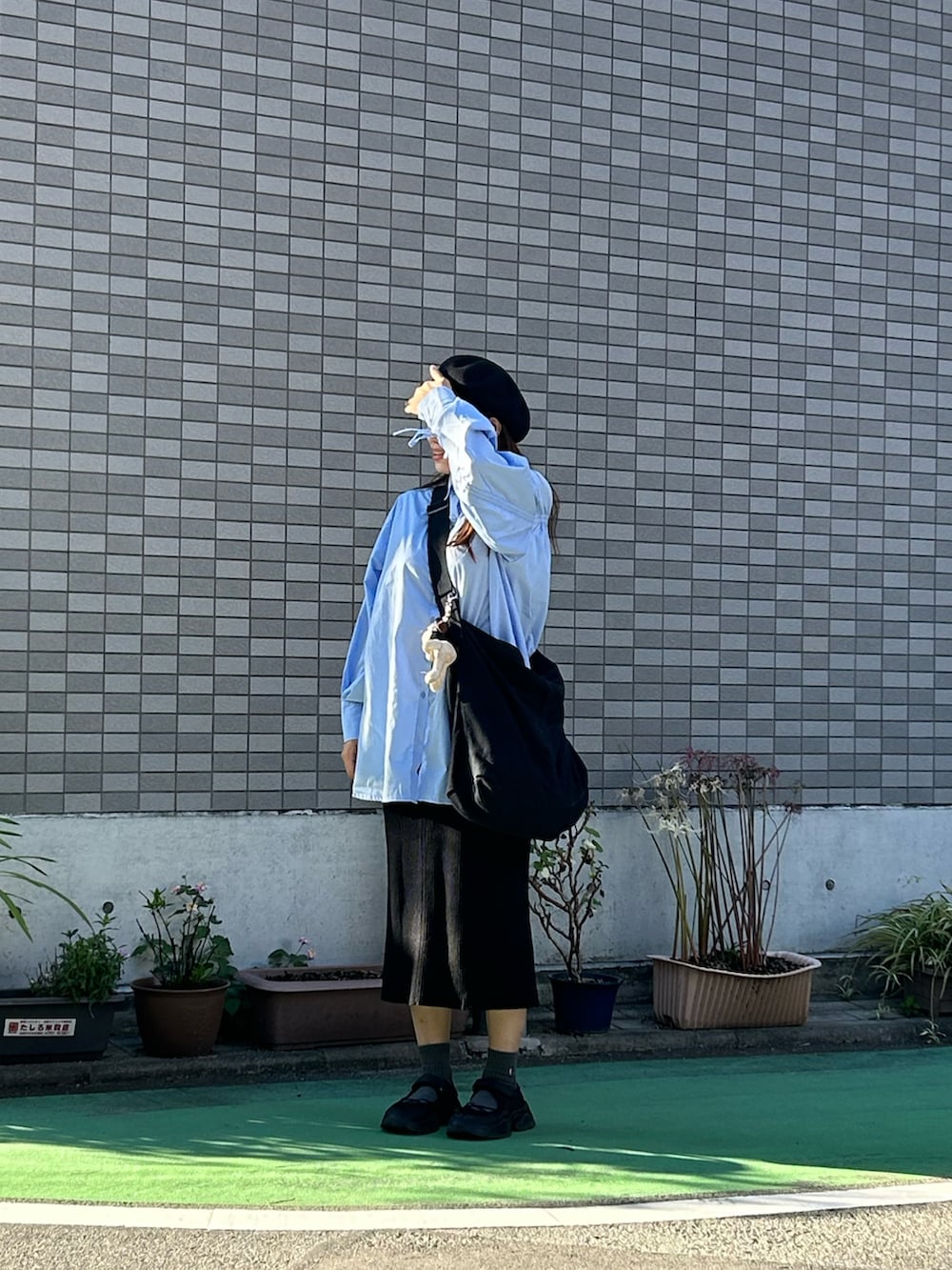 ブラック系のショルダーバッグ、ブラック系のスニーカー、ブルー系のシャツ/ブラウスを着用したレディースの秋コーディネートの2枚目の写真