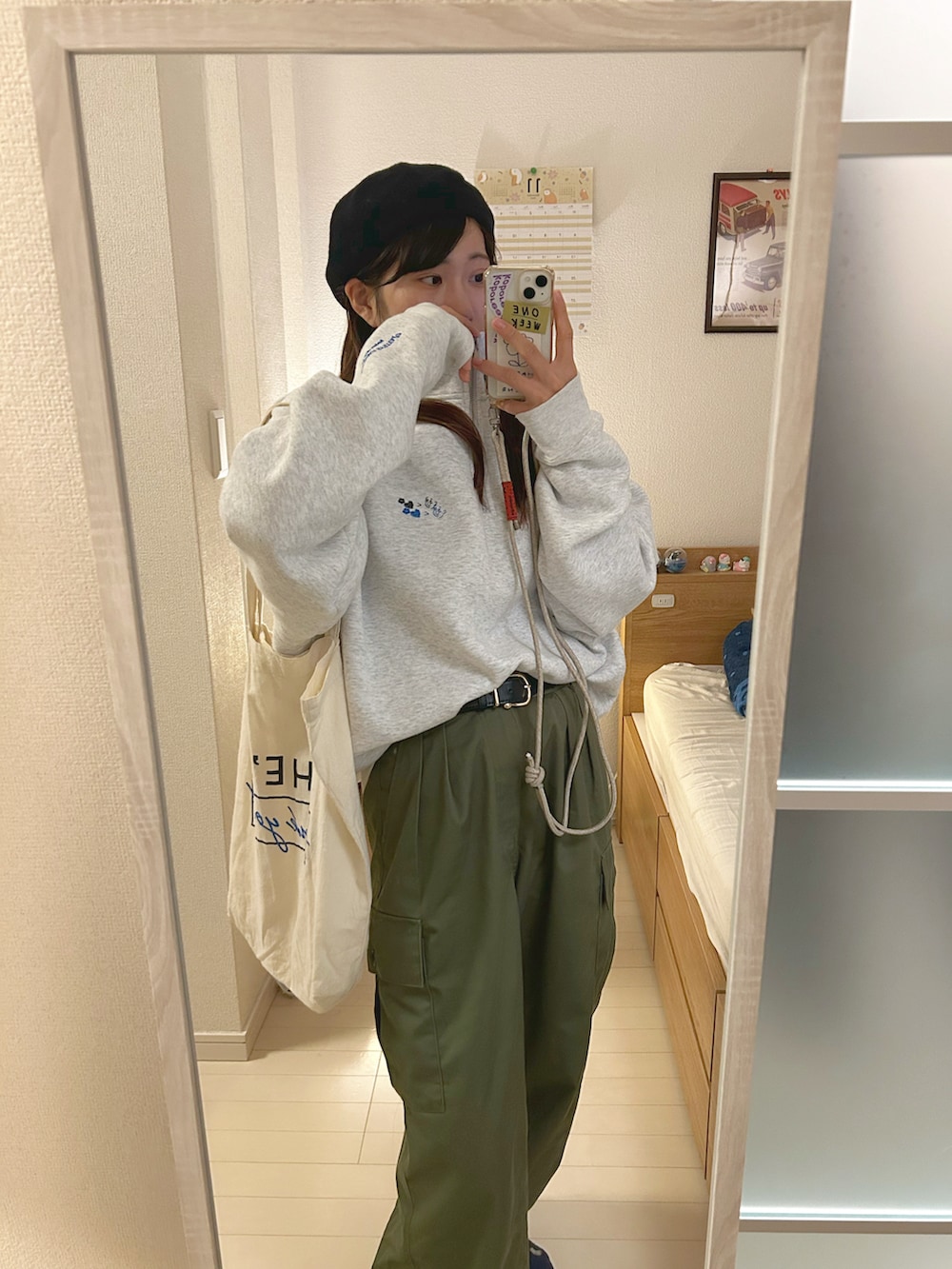 グレー系のスウェット、グリーン系のカーゴパンツ、ブラック系のスニーカーを着用したレディースの秋コーディネートの2枚目の写真