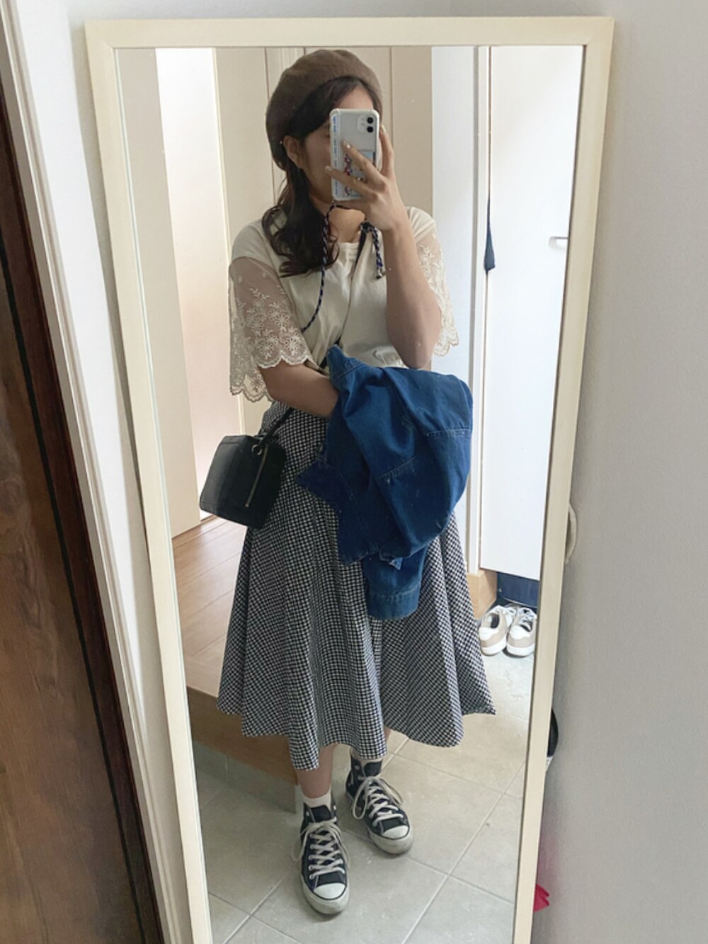 ブルー系のデニムジャケット、ホワイト系のTシャツ/カットソー、ブラック系のスカートを着用したレディースの冬コーディネートの2枚目の写真