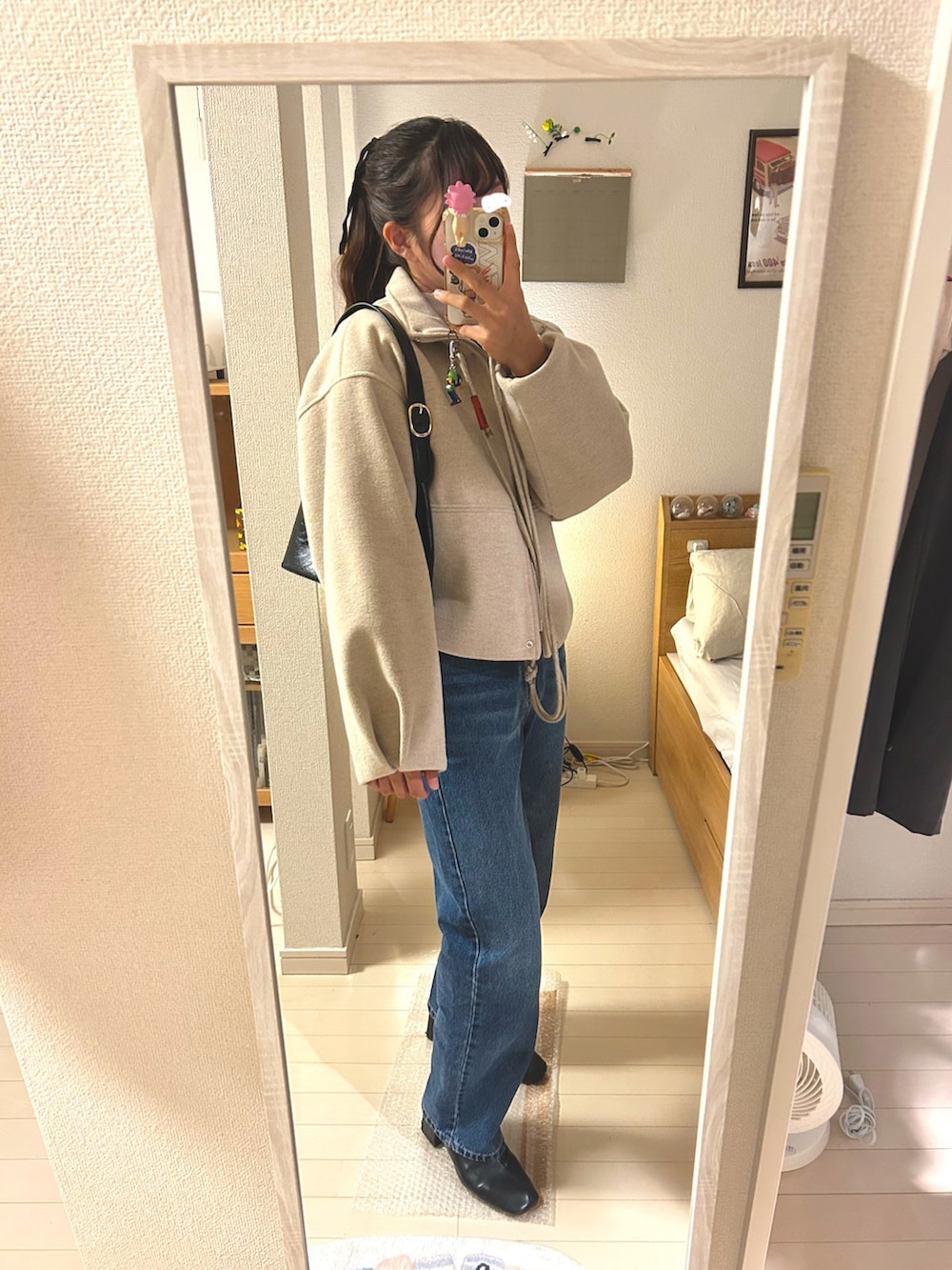 ホワイト系のTシャツ/カットソー、ブラック系のニット/セーター、ブルー系のデニムパンツを着用したレディースの秋コーディネートの2枚目の写真