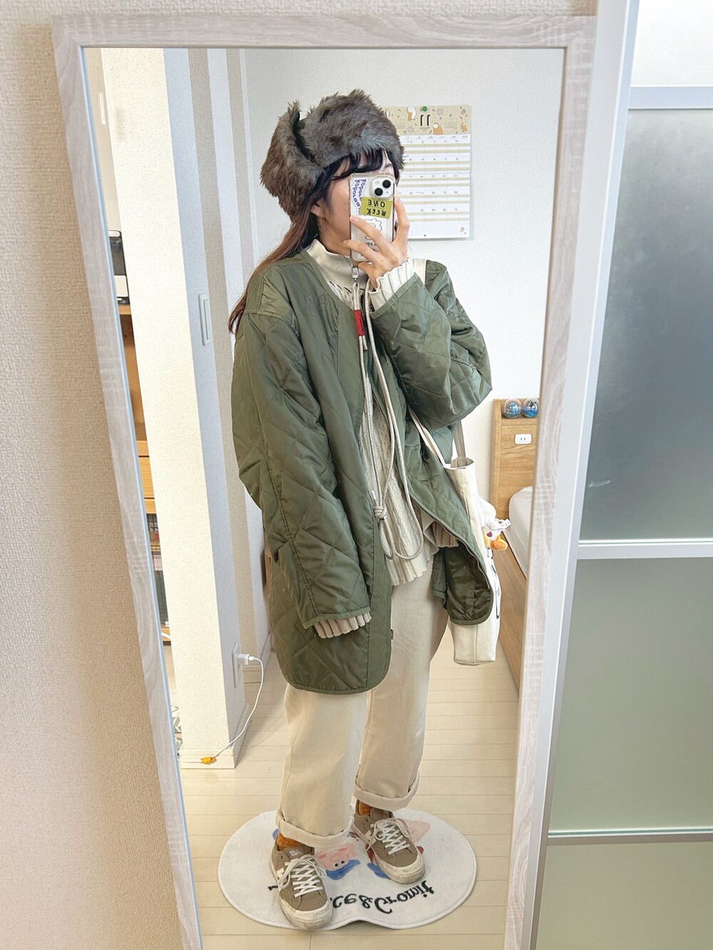 ホワイト系のニット/セーター、ホワイト系のデニムパンツ、ベージュ系のスニーカーを着用したレディースの冬コーディネートの2枚目の写真