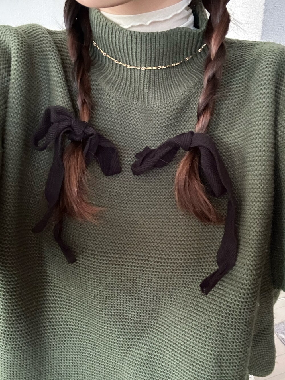 ホワイト系のTシャツ/カットソー、グリーン系のニット/セーター、ブラウン系のパンツを着用したレディースの冬コーディネートの2枚目の写真