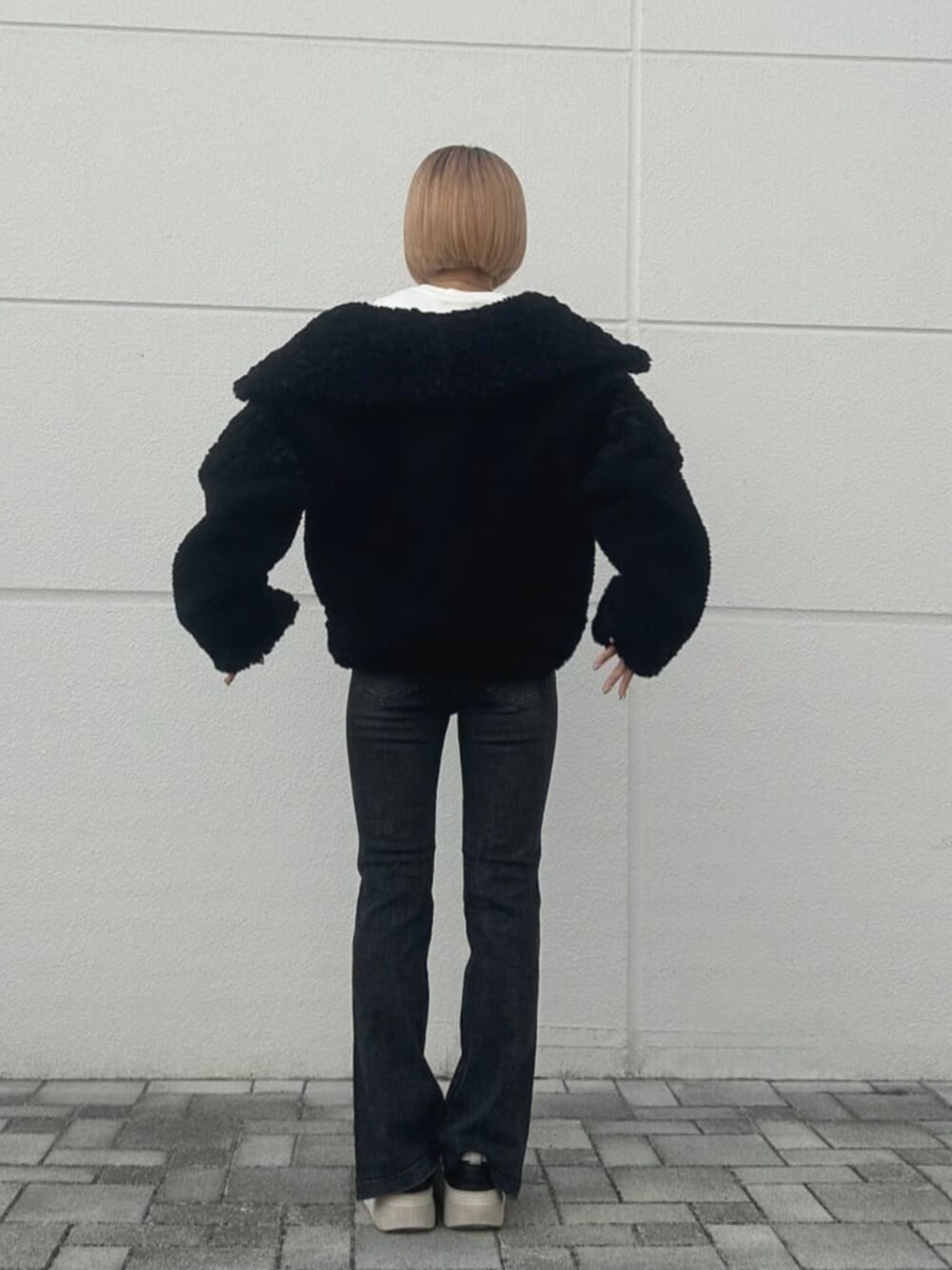 ベージュ系のニット/セーター、ブラック系のその他アウターを着用したレディースの秋コーディネートの2枚目の写真