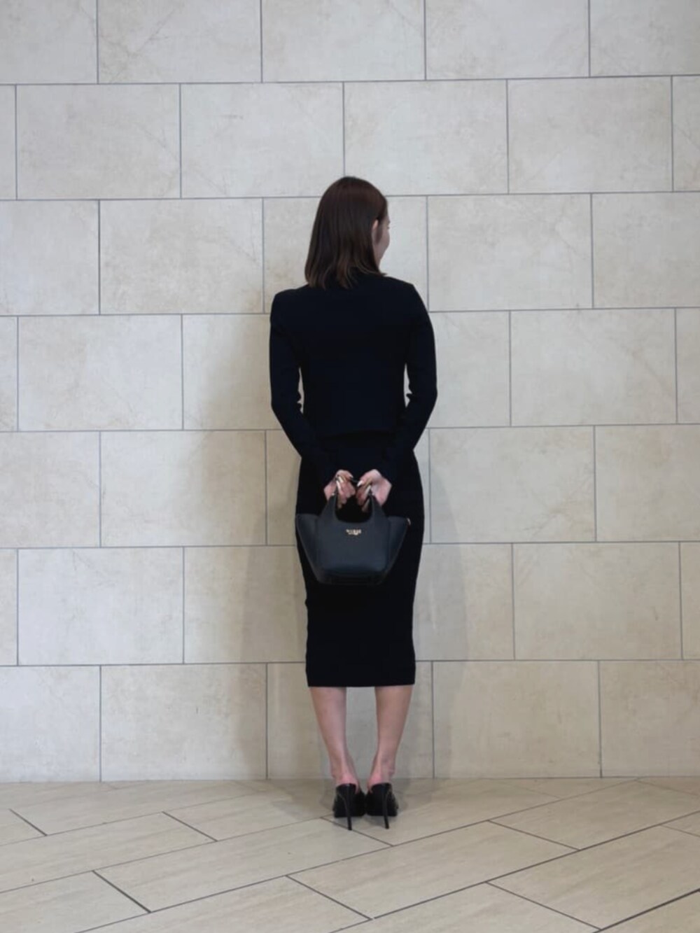 ブラック系のカーディガン/ボレロ、ブラック系のスカート、ブラック系のショルダーバッグを着用したレディースの秋コーディネートの2枚目の写真