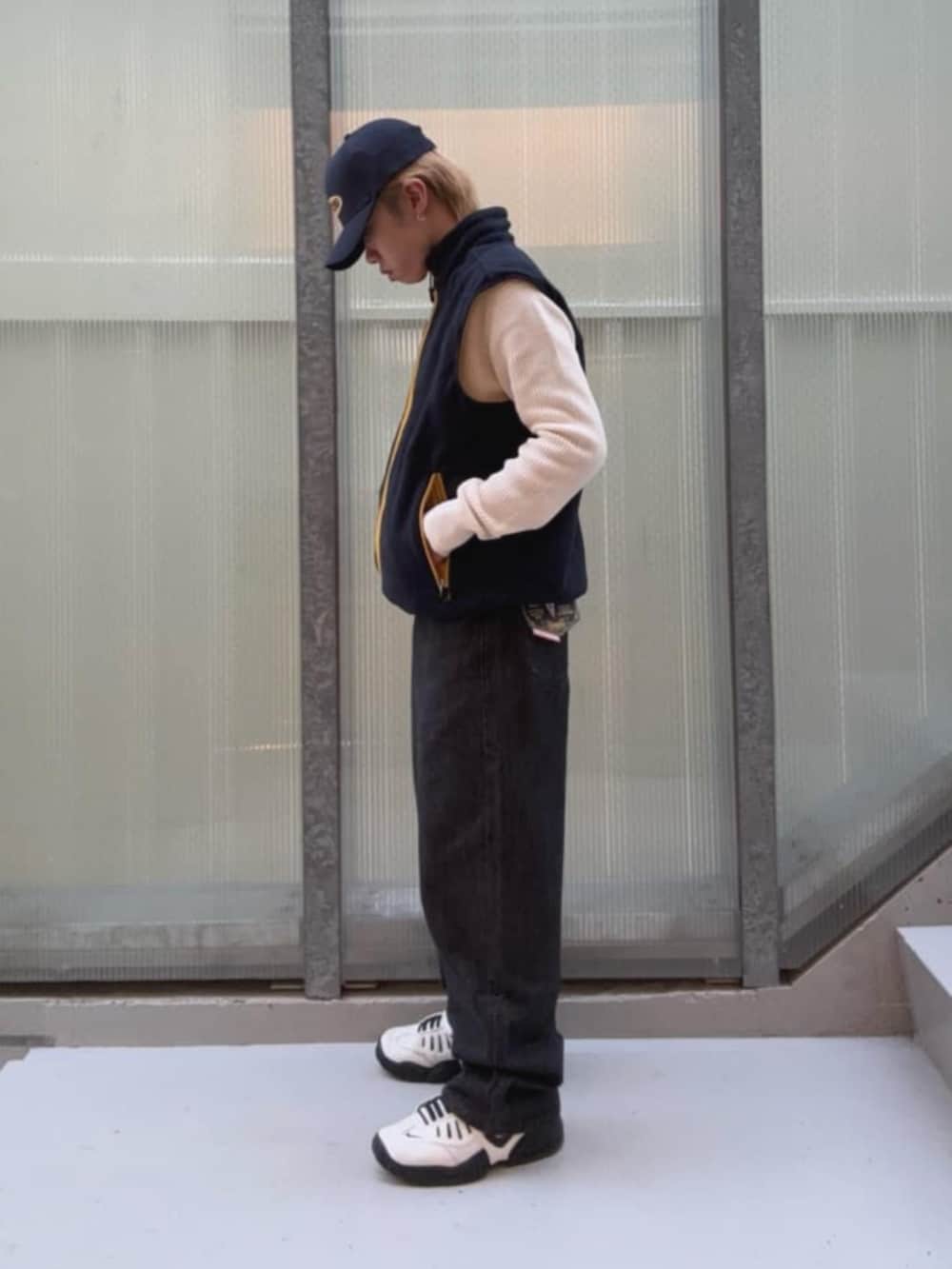 ブラック系のデニムパンツ、イエロー系のベスト、その他のボクサーパンツを着用したメンズの秋コーディネートの3枚目の写真