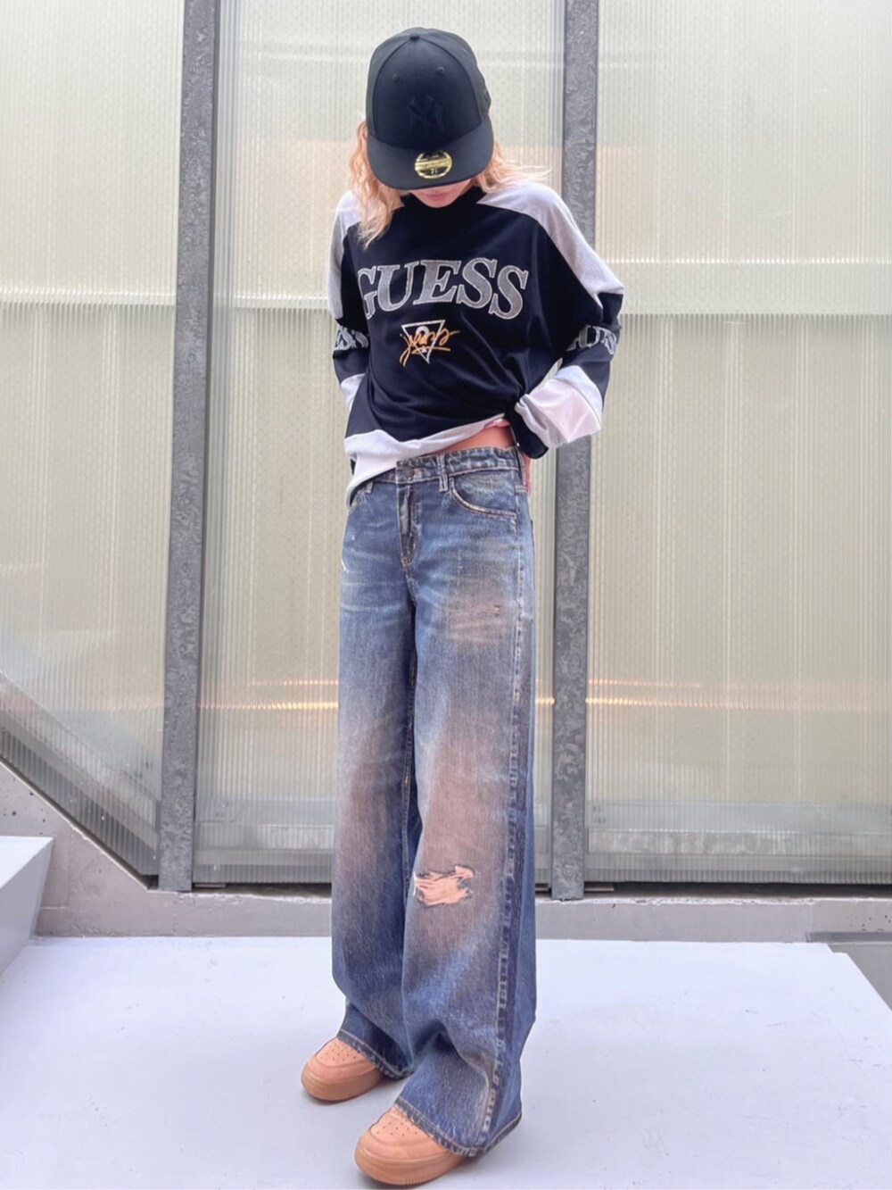 ブラック系のスウェット、ブルー系のデニムパンツを着用したレディースの夏コーディネートの5枚目の写真