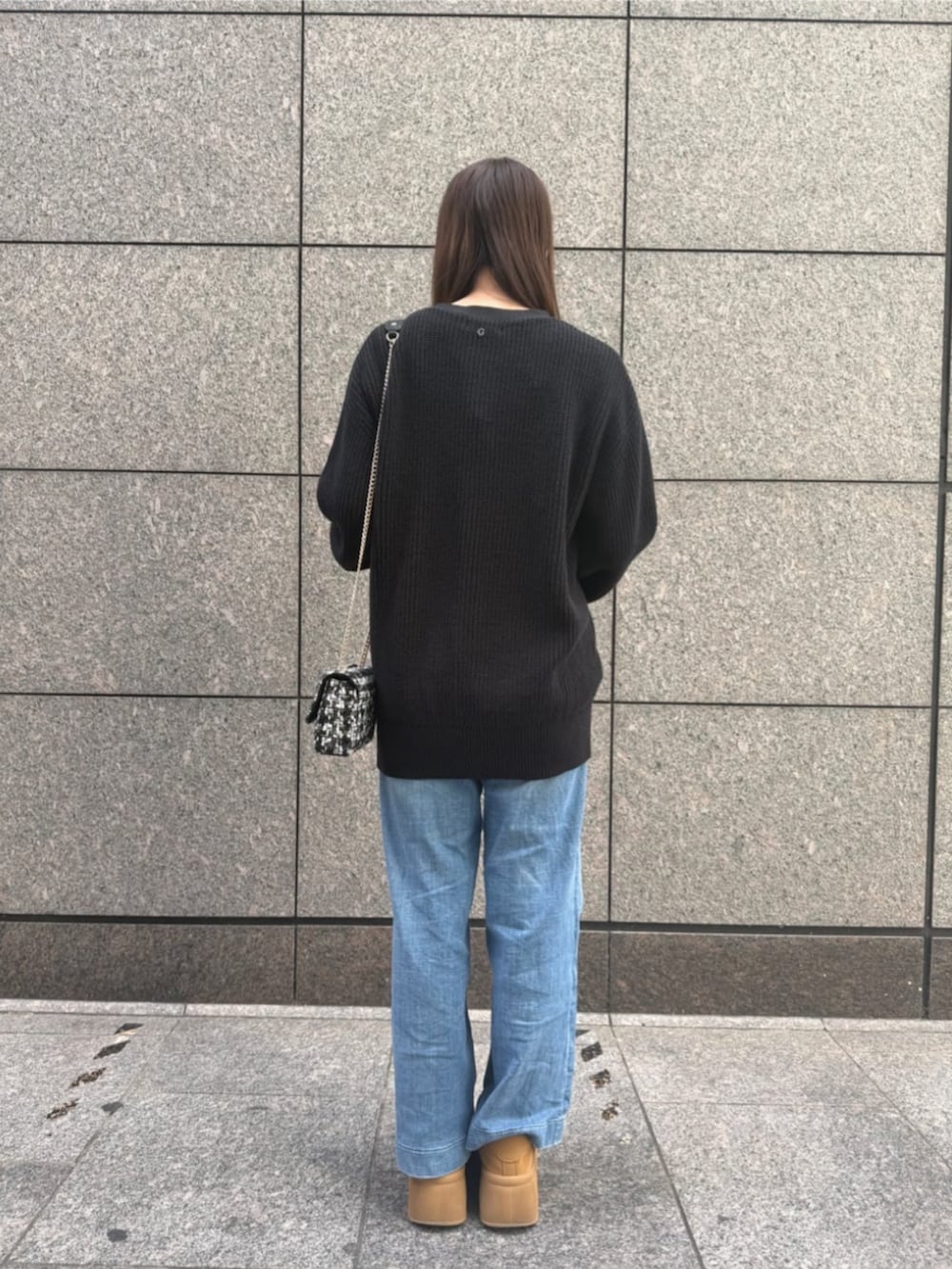 ブルー系のデニムパンツ、ブラック系のカーディガン/ボレロ、ブラック系のショルダーバッグを着用したレディースの秋コーディネートの2枚目の写真