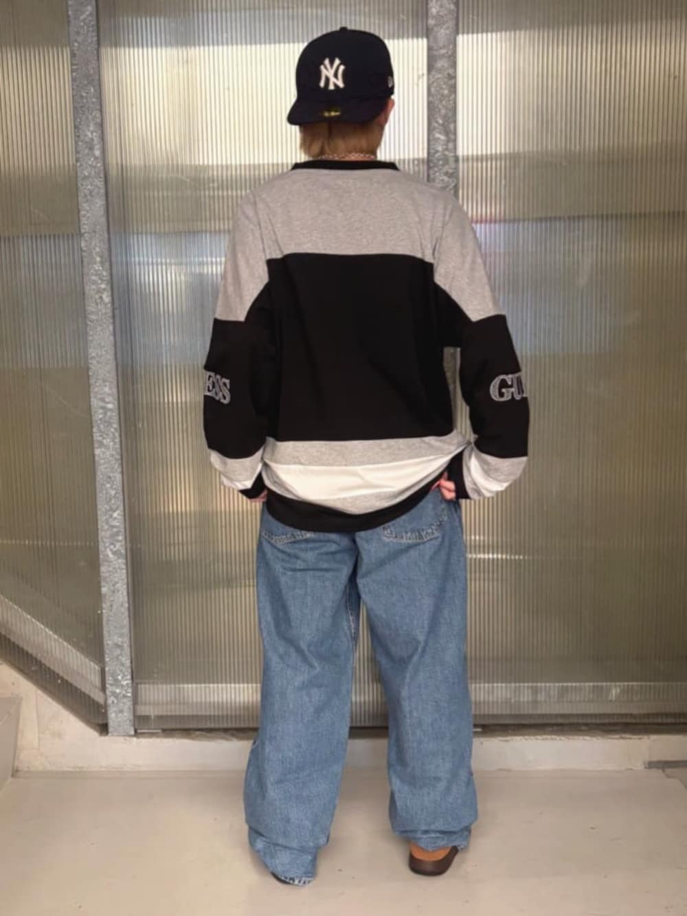 ブラック系のスウェット、ブルー系のデニムパンツ、その他のボクサーパンツを着用したメンズの秋コーディネートの2枚目の写真