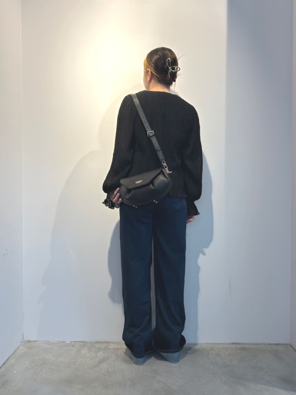 ブルー系のデニムパンツ、ブラック系のショルダーバッグ、ブラック系のシャツ/ブラウスを着用したレディースの冬コーディネートの2枚目の写真