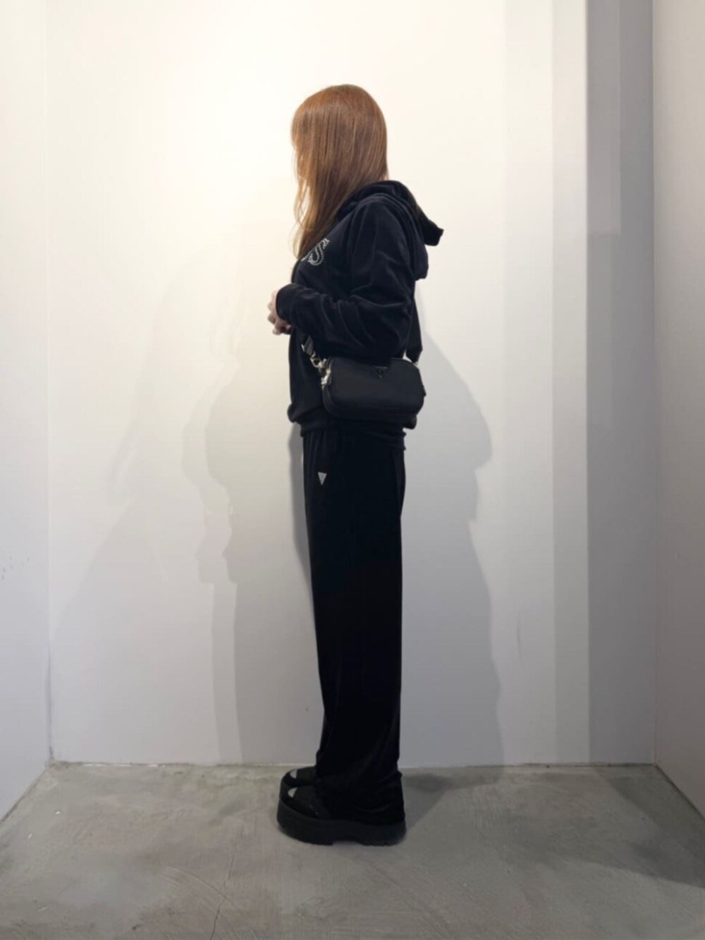 ブラック系のショルダーバッグ、ブラック系のパーカー、ブラック系のスウェットパンツを着用したレディースの春コーディネートの3枚目の写真