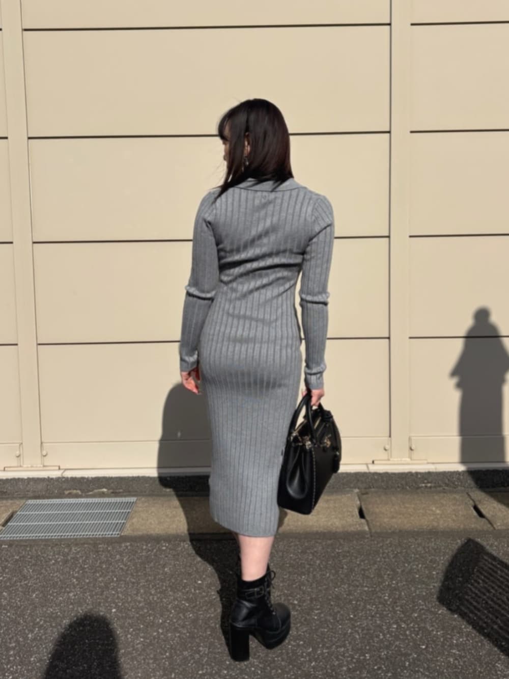 ブラック系のショルダーバッグ、グレー系のワンピースを着用したレディースの冬コーディネートの2枚目の写真